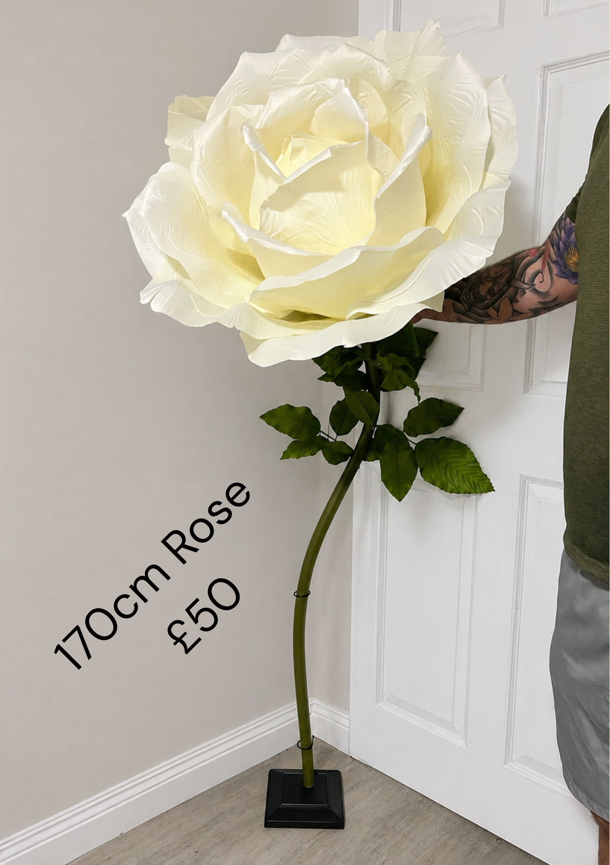 Giant ivory artificial rose with green stem and leaves; black display stand not included