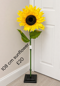 108cm yellow artificial sunflower with dark centre and green leaves; black display stand not included
