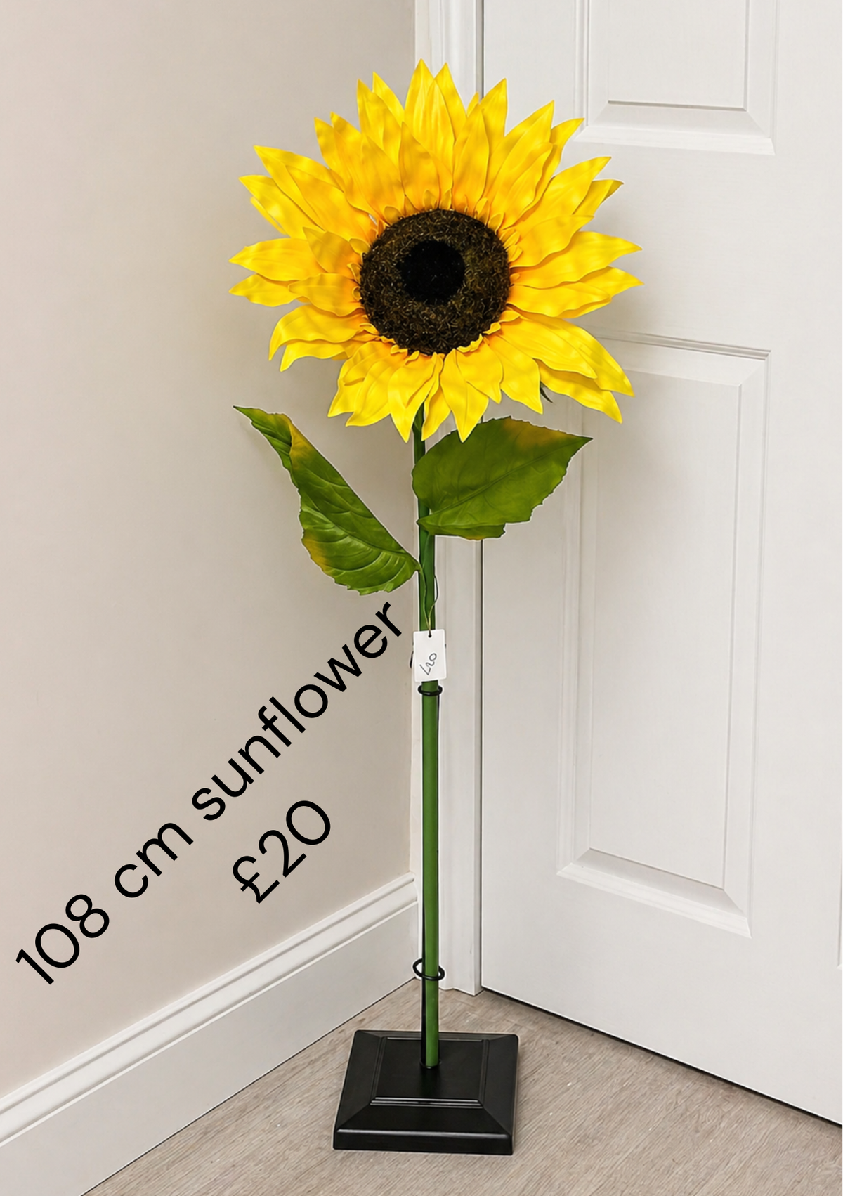 108cm yellow artificial sunflower with dark centre and green leaves; black display stand not included