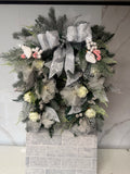 Silver and ivory horseshoe Christmas wreath with ivory flowers, frosted greenery, a silver bow and white bird decorations