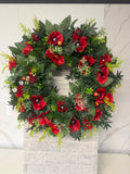 Round wreath with red poppies and mixed green foliage