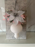 Blush pink and white Christmas hanging arrangement with a silver-edged white flower, pink foliage and white spiral-ridged ornament