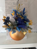 Blue and gold Christmas hanging arrangement with blue flowers, gold leaves and berries, mesh ribbon and a round gold bauble