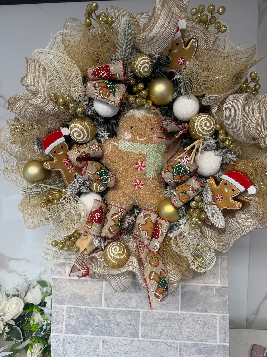 Close-up of gingerbread Christmas wreath showing central gingerbread figure and gold decorations
