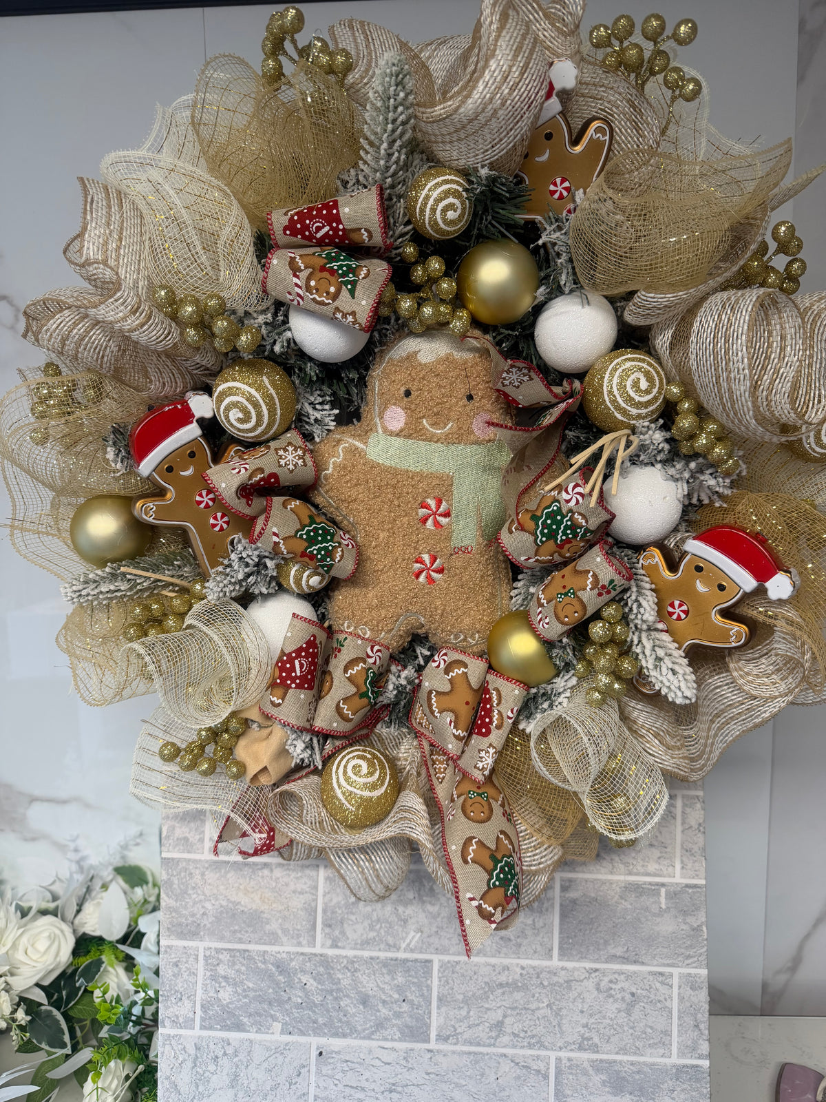 Close-up of gingerbread Christmas wreath showing central gingerbread figure and gold decorations